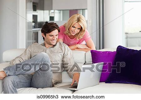 Stock Image - Couple using laptop at home. Fotosearch