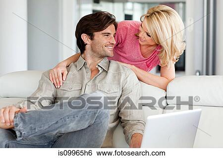 Stock Photograph - Couple using laptop at home. Fotosearch