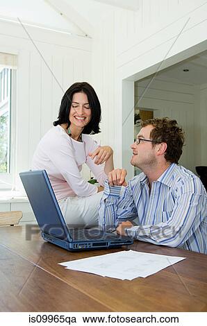 Couple using laptop in kitchen View Large Photo Image Stock Image - Couple using laptop in kitchen. Fotosearch