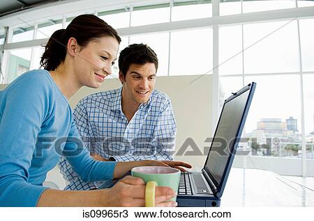 Stock Image - Couple using laptop. Fotosearch