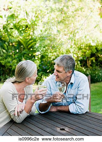 Stock Image - Couple with wine in garden. Fotosearch