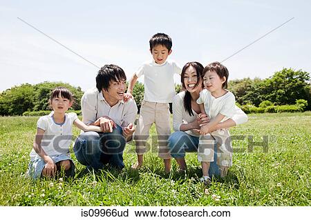 Stock Image - Family with three children in field. Fotosearch