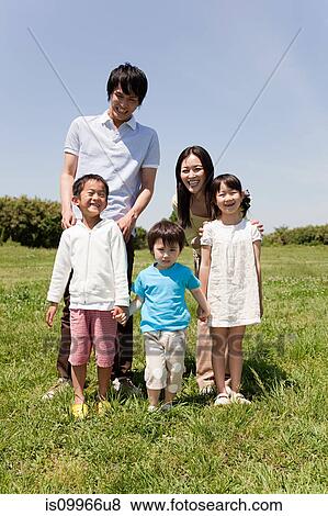 Stock Photo - Family with three children in field, portrait. Fotosearch
