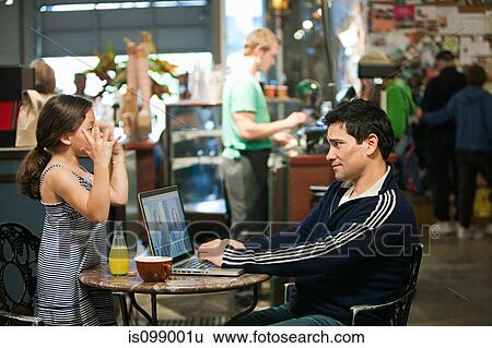 Stock Photograph - Father and daughter with laptop in cafe. Fotosearch