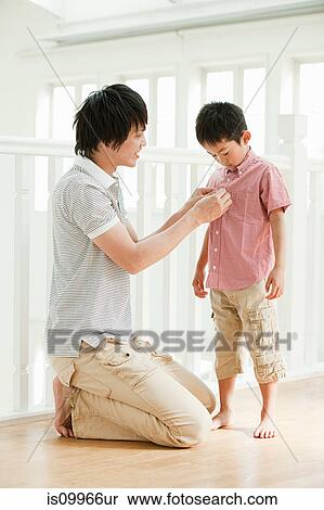 Father buttoning son's shirt View Large Photo Image Stock Photography - Father buttoning son's shirt. Fotosearch