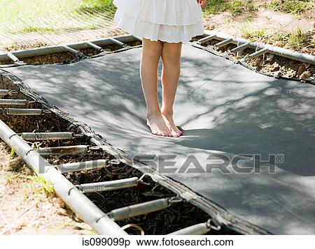 Stock Photography - Girl bouncing on trampoline, low section. Fotosearch
