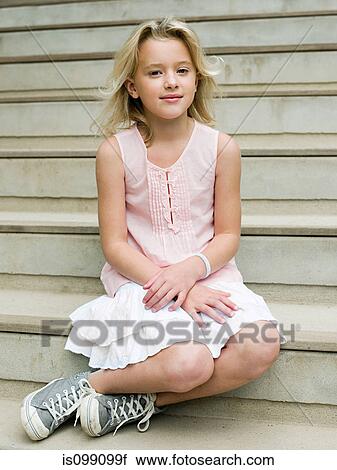 Stock Image - Girl sitting on wooden steps, portrait. Fotosearch