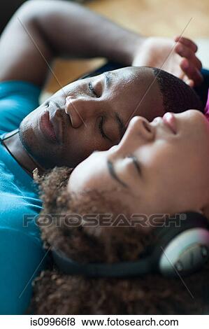 Stock Photo - Man and woman listening to music, eyes closed. Fotosearch