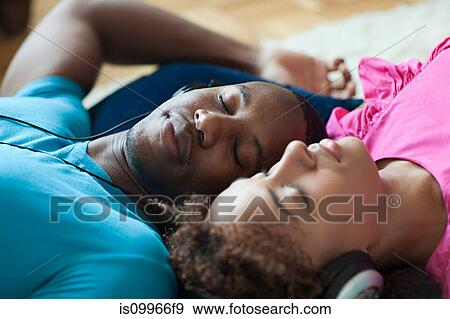 Stock Photo - Man and woman listening to music, eyes closed. Fotosearch