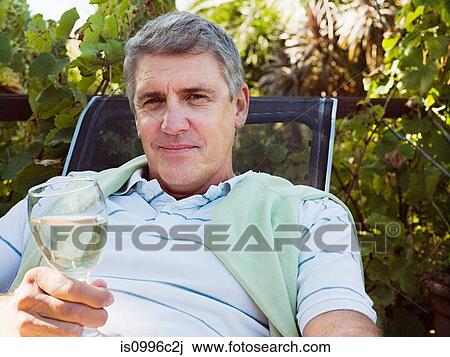 Man holding glass of white wine, portrait View Large Photo Image Stock Image - Man holding glass of white wine, portrait. Fotosearch