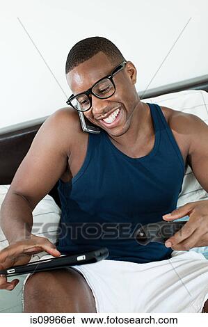 Man on smartphone with digital tablet and remote control View Large Photo Image Stock Photograph - Man on smartphone with digital tablet and remote control. Fotosearch