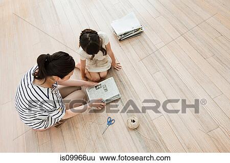 Mother and daughter with newspapers, high angle View Large Photo Image Stock Photograph - Mother and daughter with newspapers, high angle. Fotosearch