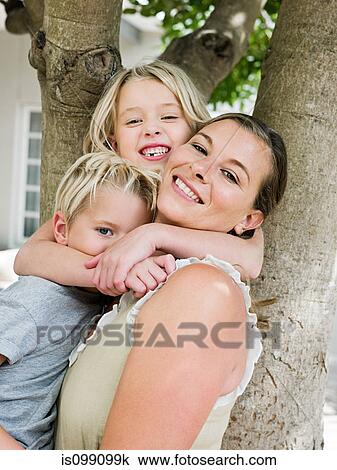 Mother with son and daughter by tree View Large Photo Image Stock Image - Mother with son and daughter by tree. Fotosearch