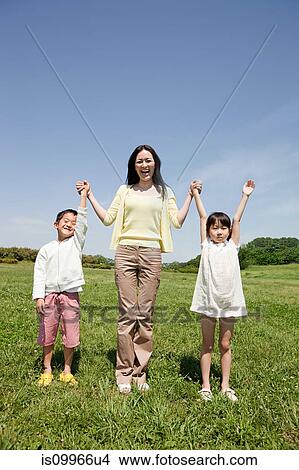 Mother with two children in field with arms up View Large Photo Image Picture - Mother with two children in field with arms up. Fotosearch