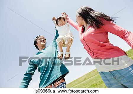 Parents lifting son mid air View Large Photo Image Stock Image - Parents lifting son mid air. Fotosearch