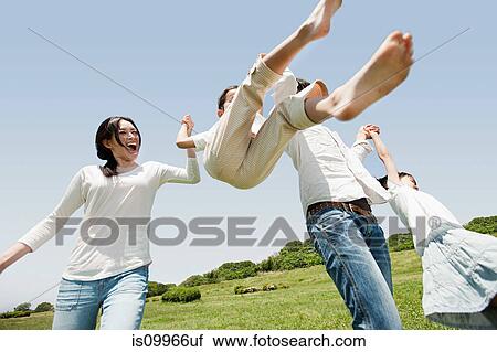 Parents lifting son mid air View Large Photo Image Stock Image - Parents lifting son mid air. Fotosearch