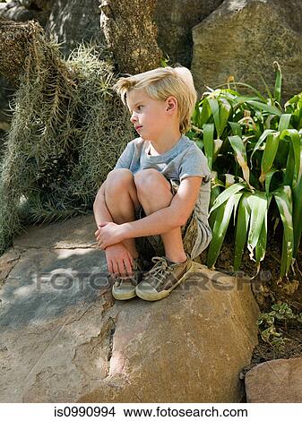 Pensive boy sitting on rock View Large Photo Image Picture - Pensive boy sitting on rock. Fotosearch
