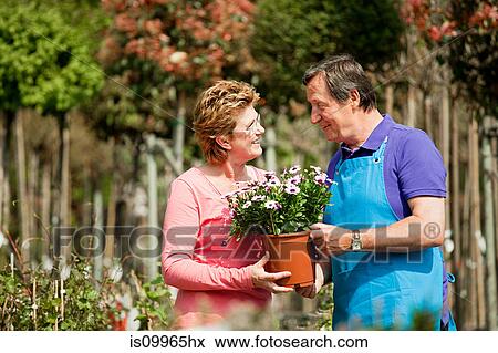 Woman buying plants at garden center View Large Photo Image Stock Photo - Woman buying plants at garden center. Fotosearch