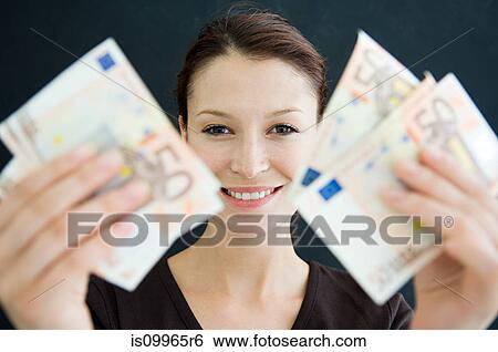 Stock Photograph - Woman holding 50 Euro banknotes. Fotosearch