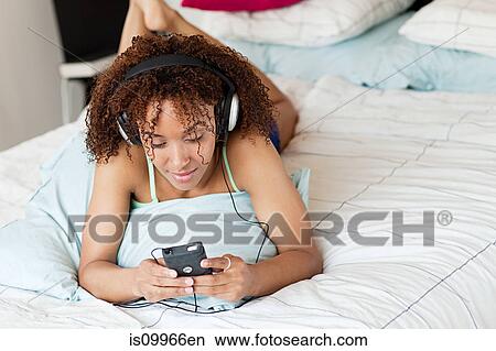 Woman listening to music on mp3 player View Large Photo Image Picture - Woman listening to music on mp3 player. Fotosearch