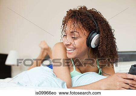 Woman listening to music on mp3 player View Large Photo Image Picture - Woman listening to music on mp3 player. Fotosearch