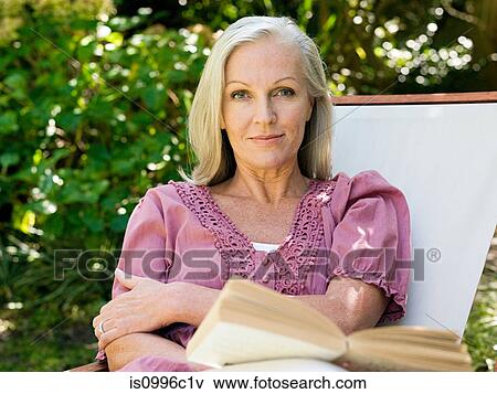 Stock Photo - Woman sitting on deckchair, portrait. Fotosearch