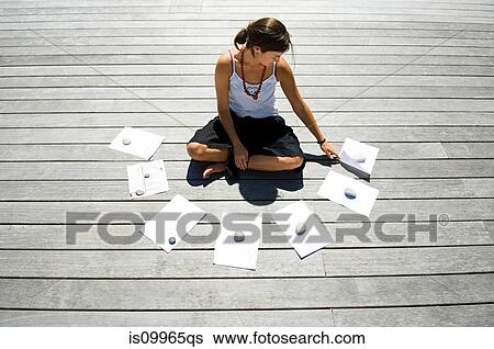Woman sitting on decking with financial documents View Large Photo Image Stock Photograph - Woman sitting on decking with financial documents. Fotosearch