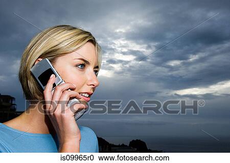Woman using cell phone against storm clouds View Large Photo Image Stock Image - Woman using cell phone against storm clouds. Fotosearch