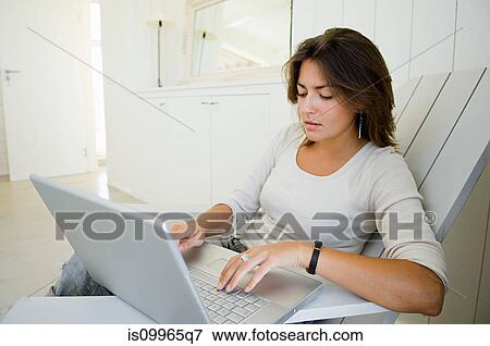 Stock Photo - Woman using laptop at home. Fotosearch