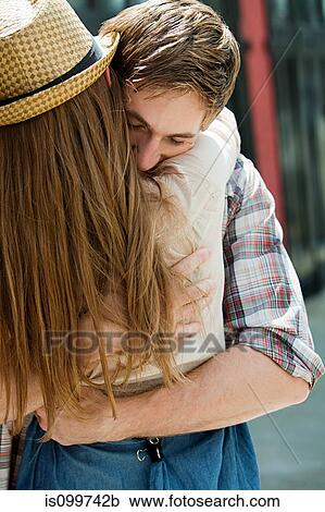 Stock Image - Young couple embracing outdoors. Fotosearch