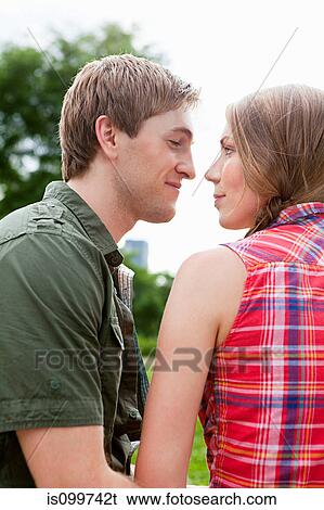 Young couple face to face outdoors View Large Photo Image Stock Photograph - Young couple face to face outdoors. Fotosearch