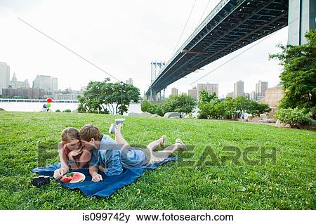 Young couple having picnic in a park View Large Photo Image Stock Photo - Young couple having picnic in a park. Fotosearch