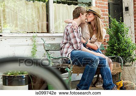 Young couple kissing on bench View Large Photo Image Stock Image - Young couple kissing on bench. Fotosearch