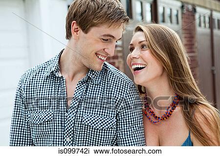 Stock Image - Young couple laughing outdoors. Fotosearch