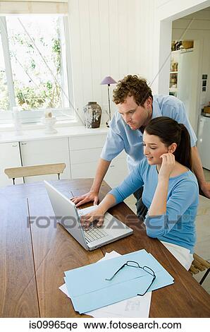 Young couple using laptop in kitchen View Large Photo Image Stock Image - Young couple using laptop in kitchen. Fotosearch