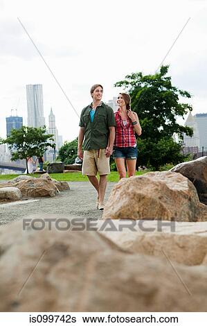 Young couple walking in city park View Large Photo Image Stock Photograph - Young couple walking in city park. Fotosearch