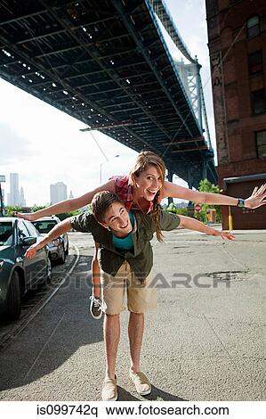 Young man carrying woman under bridge View Large Photo Image Stock Photography - Young man carrying woman under bridge. Fotosearch