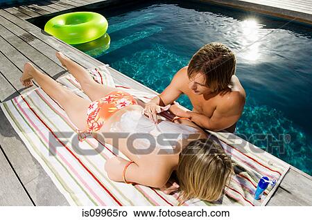 Young man drawing heart shape on woman's back with suncream View Large Photo Image Picture - Young man drawing heart shape on woman's back with suncream. Fotosearch