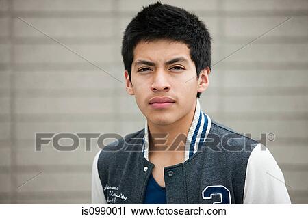Stock Image - Young man wearing baseball jacket, portrait. Fotosearch