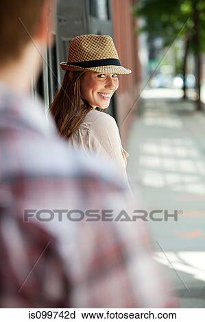 Stock Image - Young woman smiling over shoulder. Fotosearch