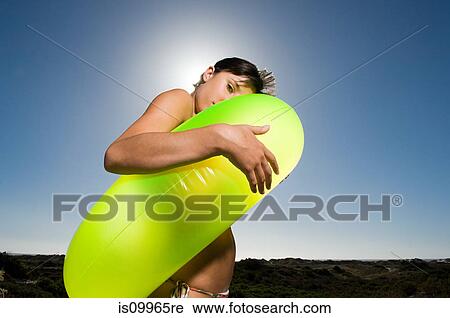Stock Image - Young woman wearing inflatable ring. Fotosearch