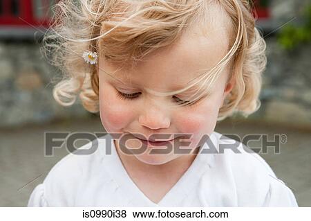 Stock Photo - Blonde girl with daisy in hair, portrait. Fotosearch
