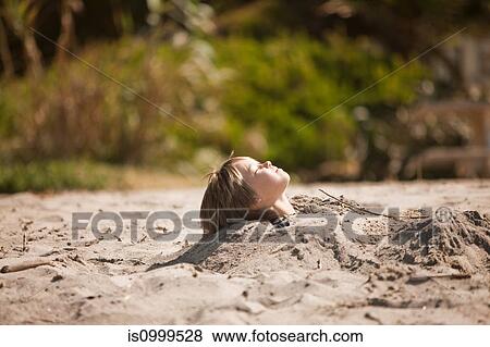Boy buried up to his neck in the sand View Large Photo Image Stock Photo - Boy buried up to his neck in the sand. Fotosearch