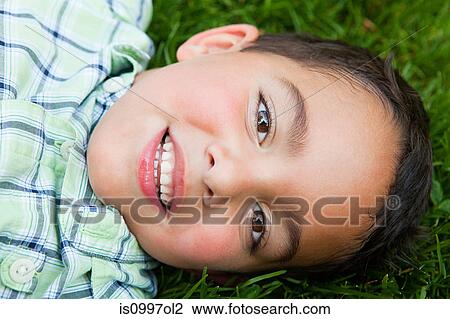 Boy smiling on grass, portrait View Large Photo Image Stock Image - Boy smiling on grass, portrait. Fotosearch