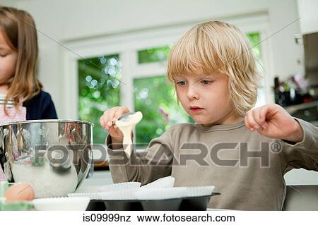 Boy spooning cake mixture into cake cases View Large Photo Image Stock Photo - Boy spooning cake mixture into cake cases. Fotosearch