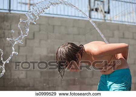 Boy squirting water over his back View Large Photo Image Stock Photo - Boy squirting water over his back. Fotosearch