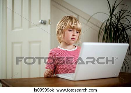 Boy using laptop on desk View Large Photo Image Stock Image - Boy using laptop on desk. Fotosearch