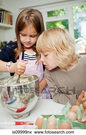 Boy watching sister mix cake ingredients View Large Photo Image Stock Photo - Boy watching sister mix cake ingredients. Fotosearch