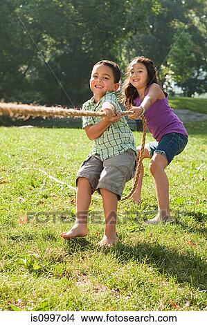 Brother and sister playing tug of war in park View Large Photo Image Picture - Brother and sister playing tug of war in park. Fotosearch