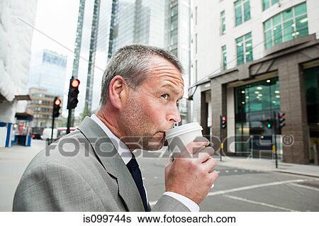 Businessman drinking coffee on the go View Large Photo Image Stock Photograph - Businessman drinking coffee on the go. Fotosearch